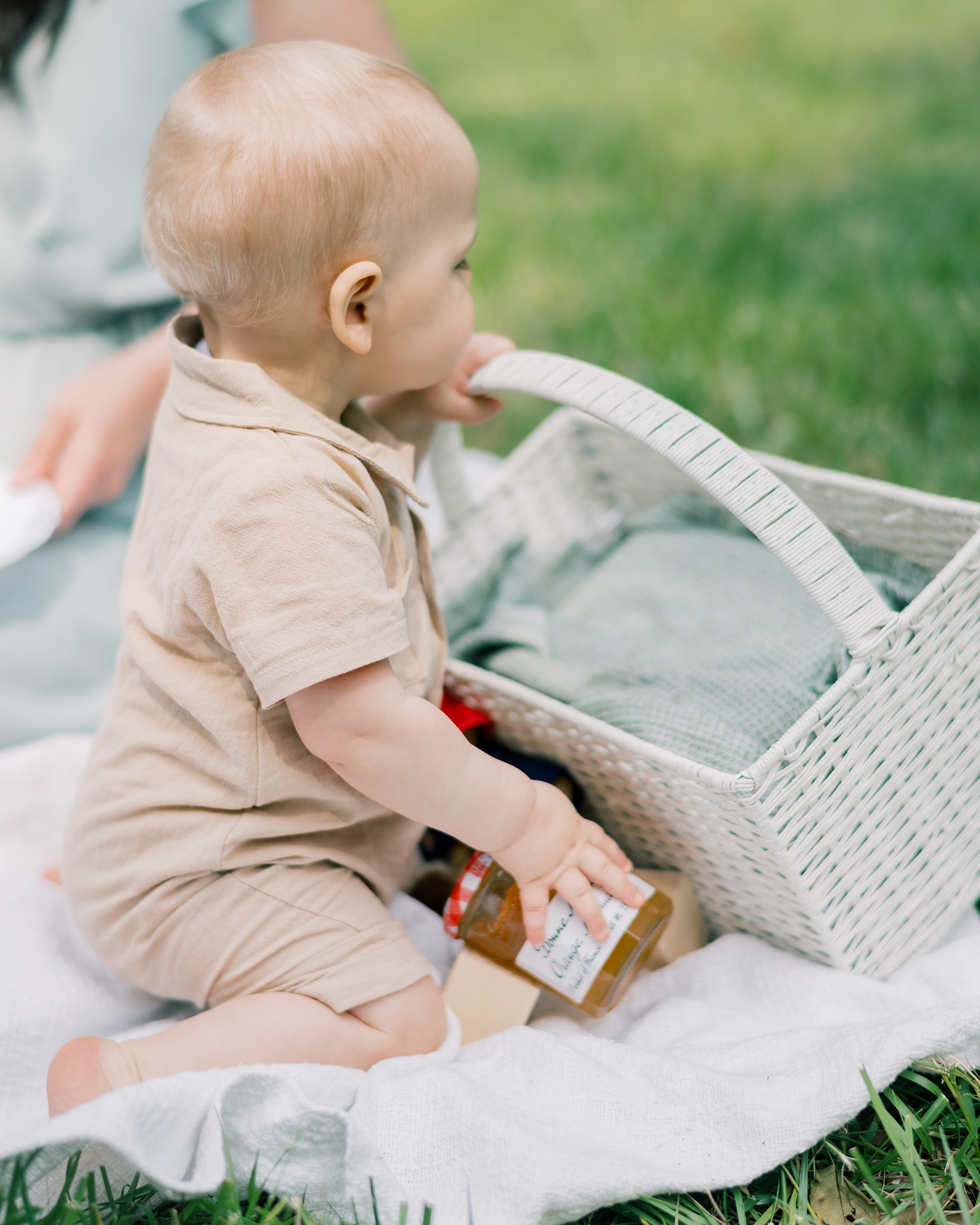 baby plays with basket and marmalade jars during Paddington inspired first birthday portraits
