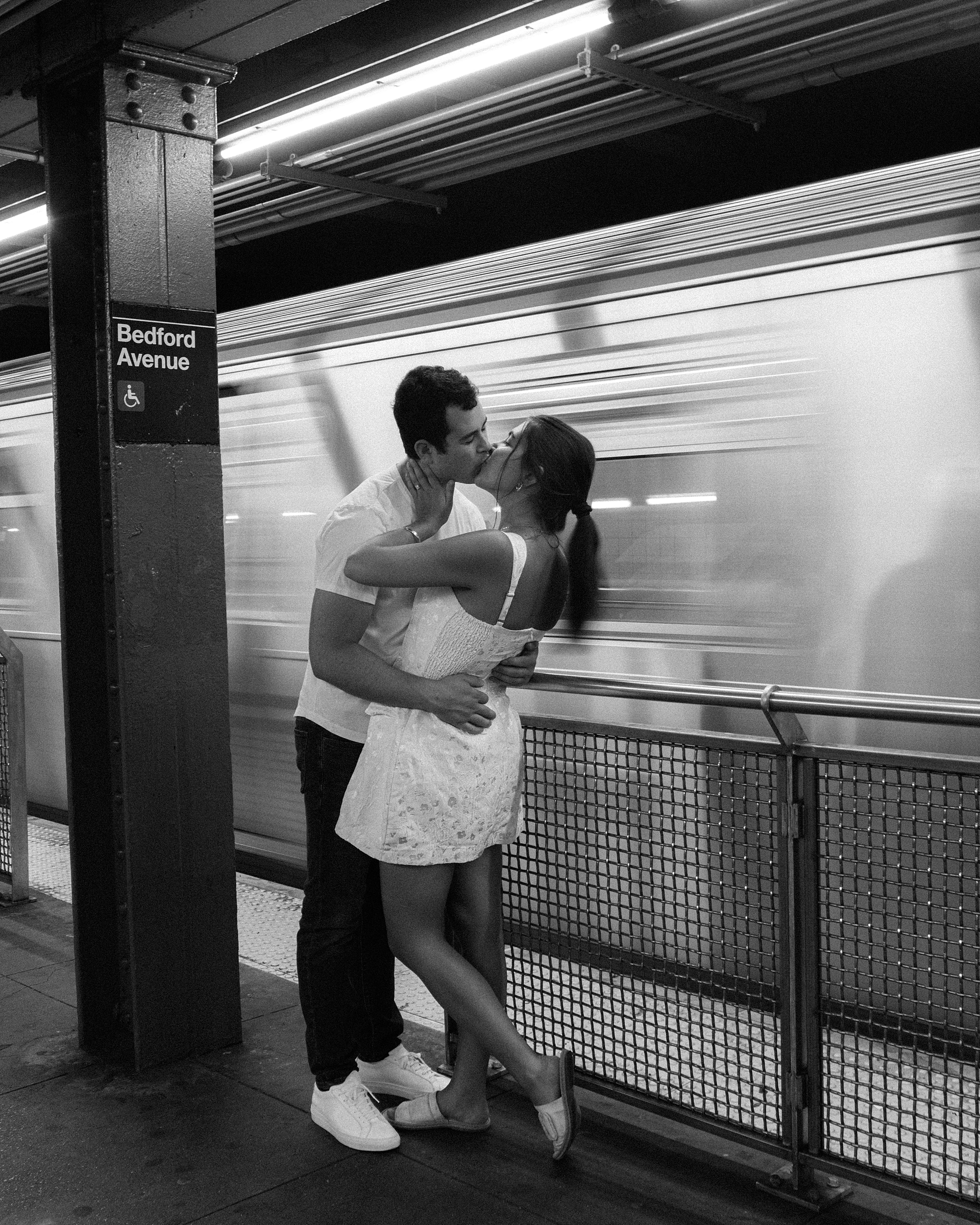 engaged couple kisses by subway train in Manhattan 