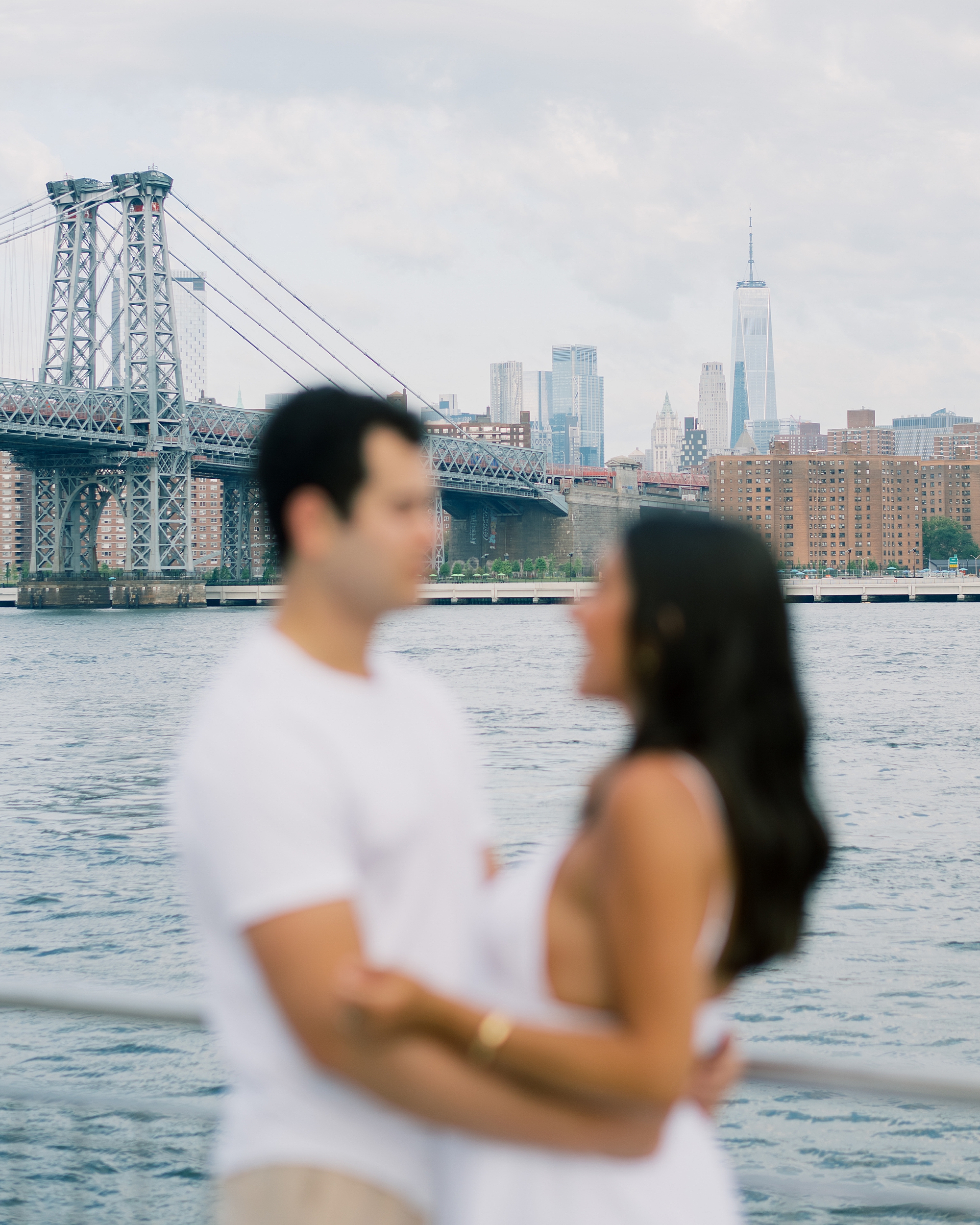 photo blurred in front of Brooklyn bridge at Domino Park