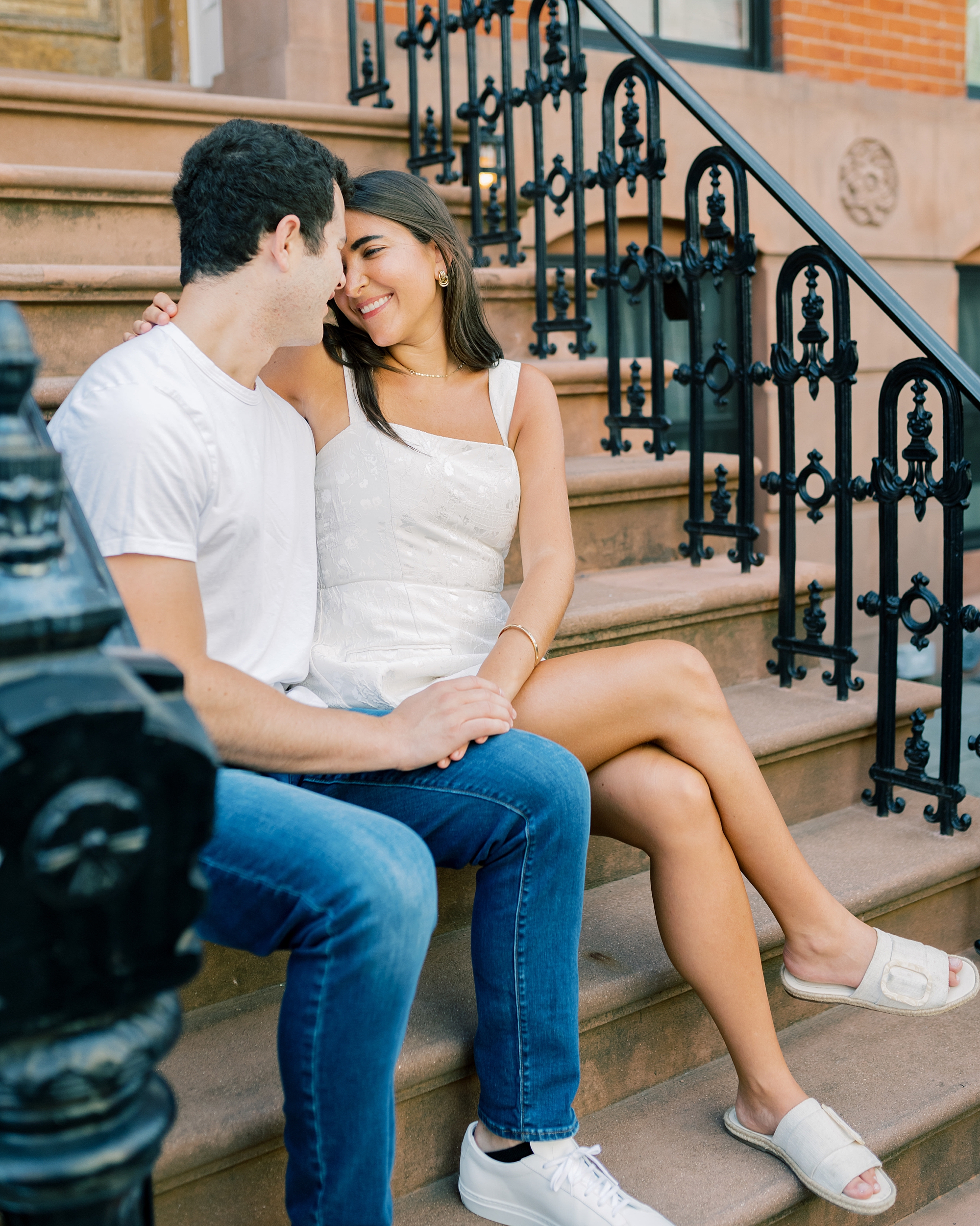 man and woman sit on steps of Williamsburg NY home