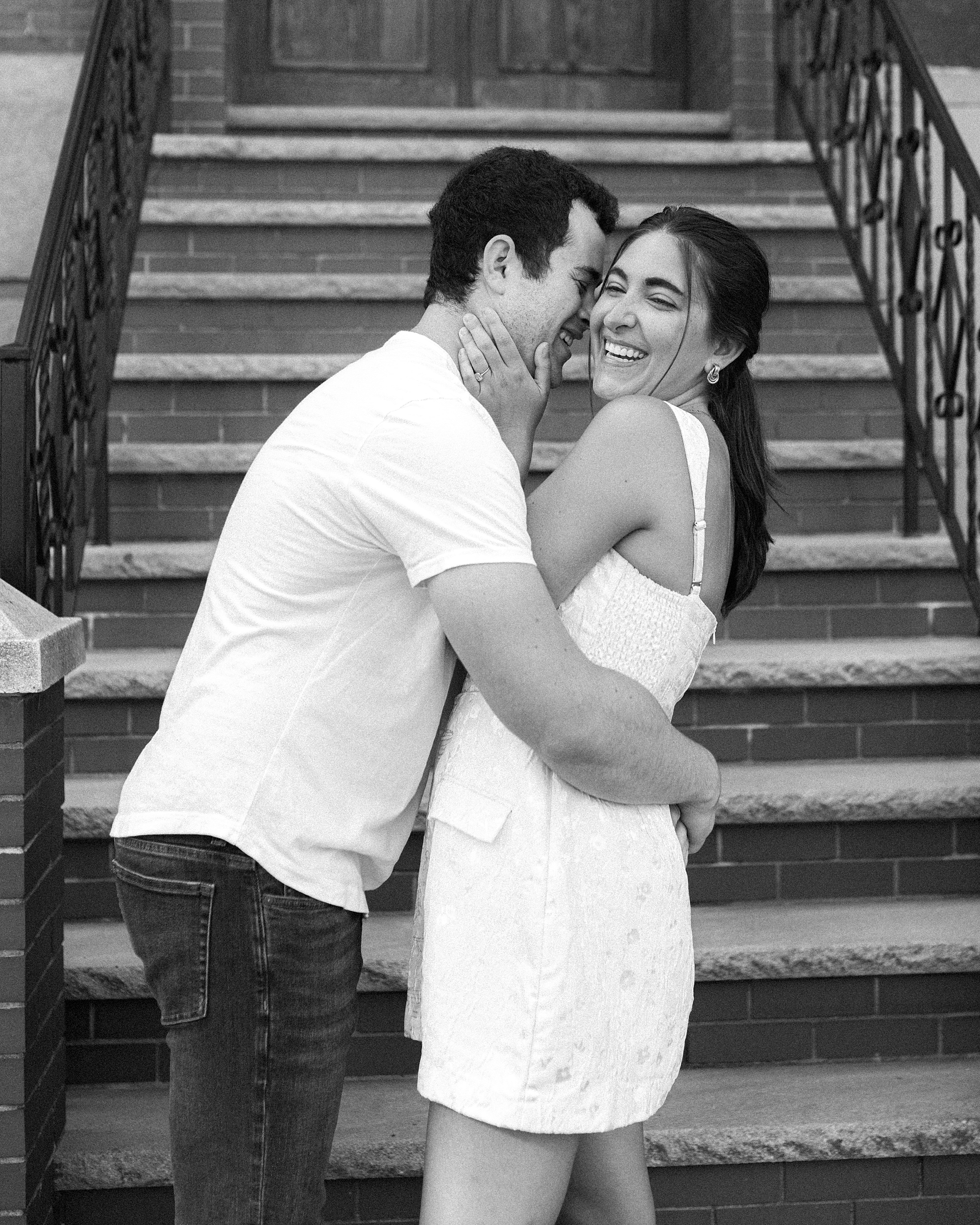 man hugs woman around waist in front of neighborhood steps