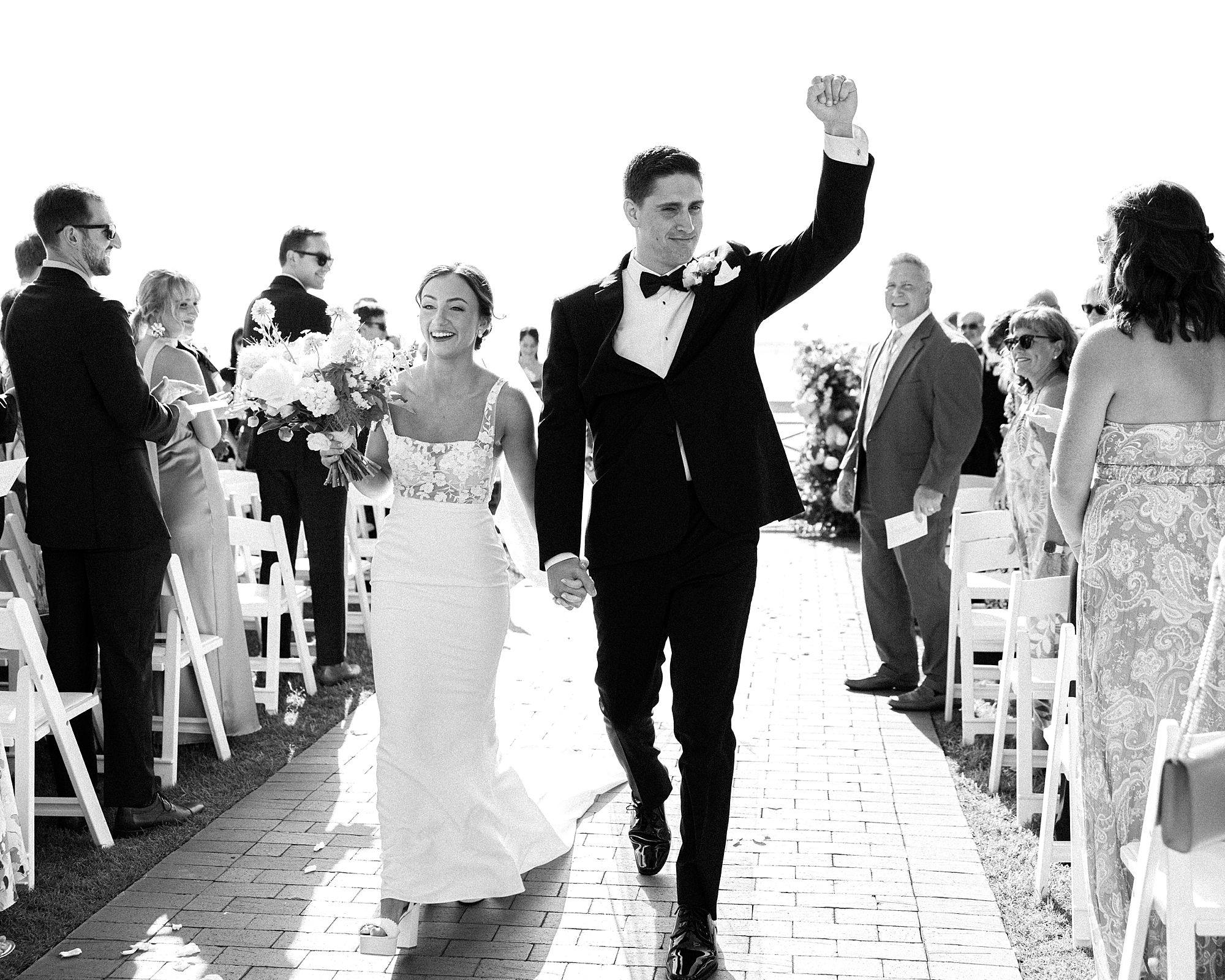 bride and groom cheer walking up aisle at Chesapeake Bay Beach Club