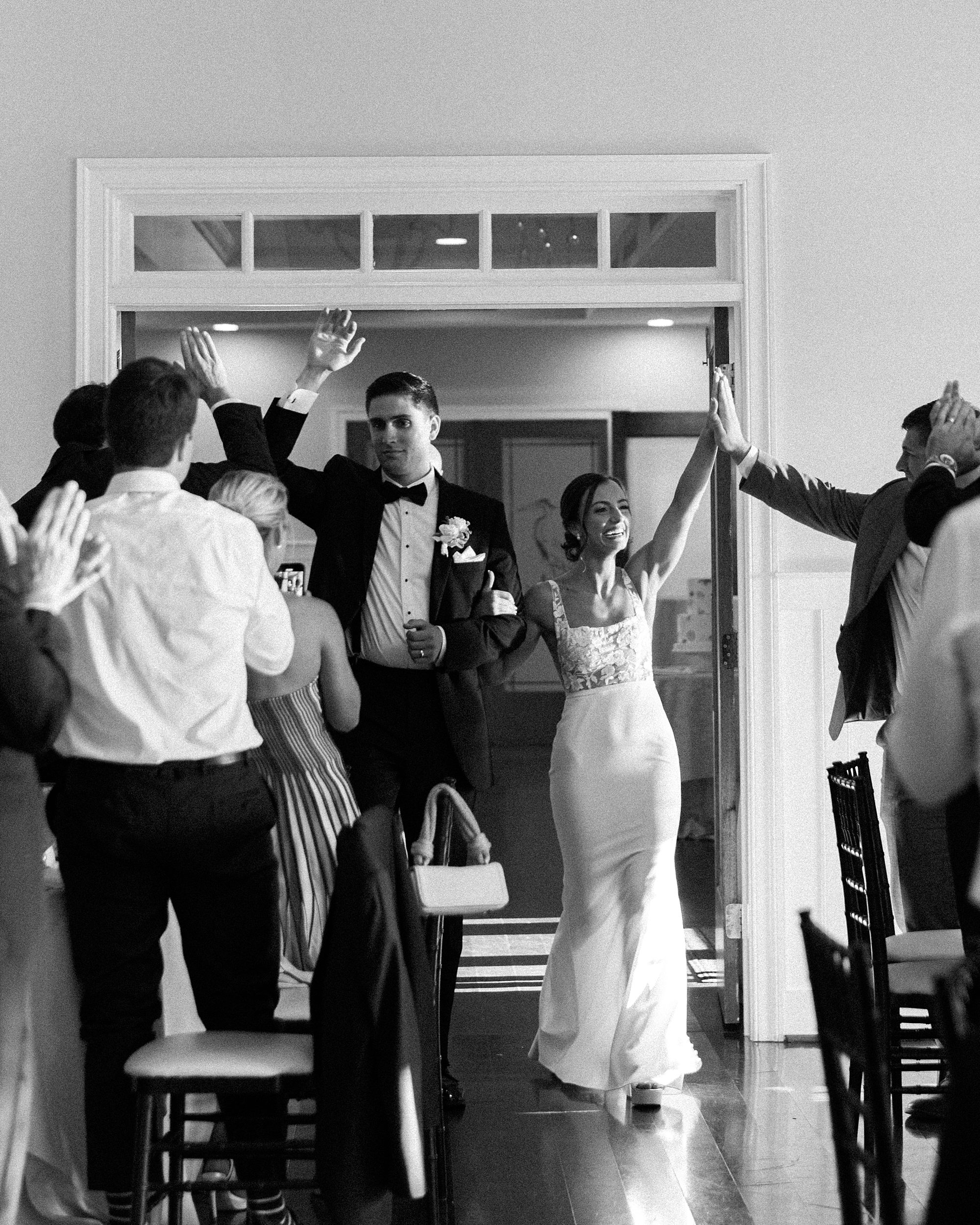 bride and groom cheer walking into reception at Chesapeake Bay Beach Club
