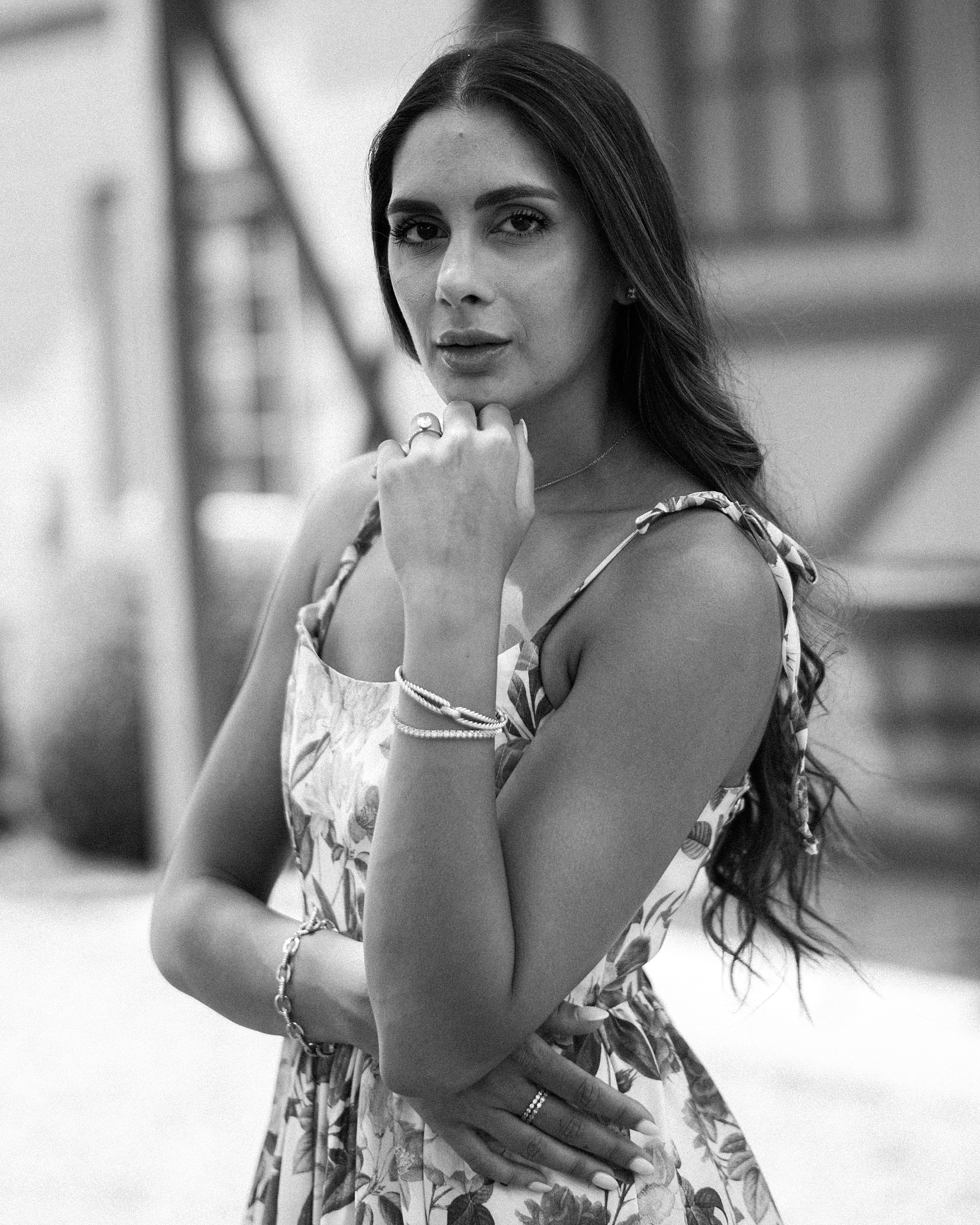 woman poses in floral print dress outside barn 