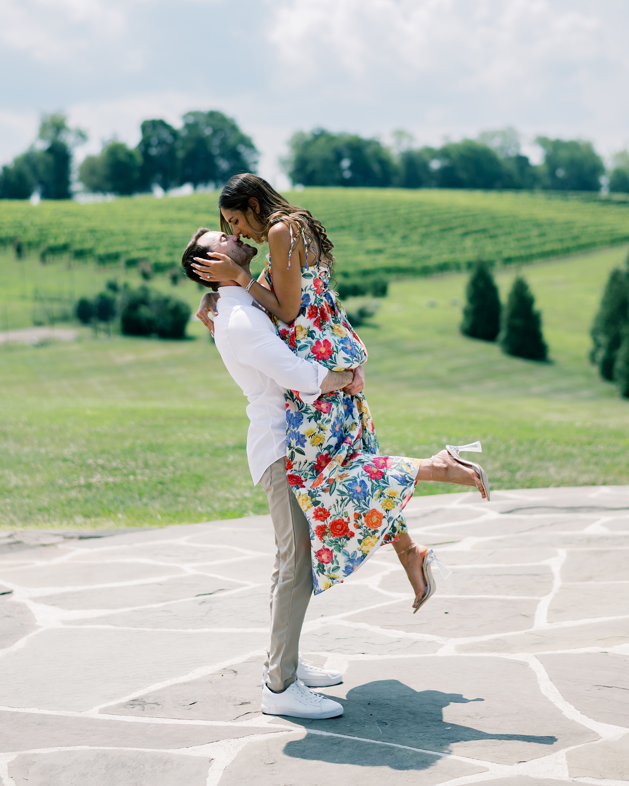man lifts up woman kissing her on stone patio at Stone Tower Winery