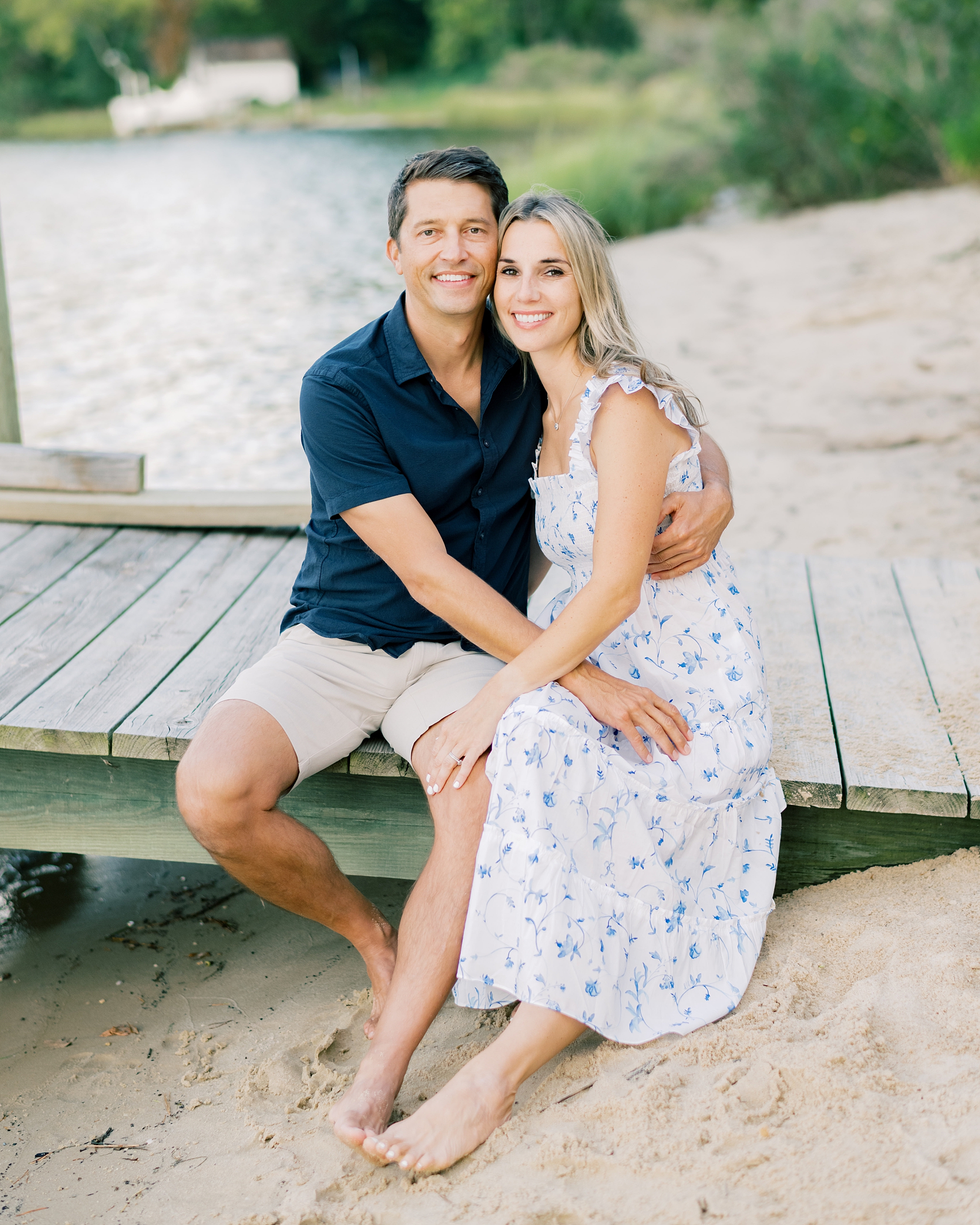 couple sits on pier together during Southern Maryland family session