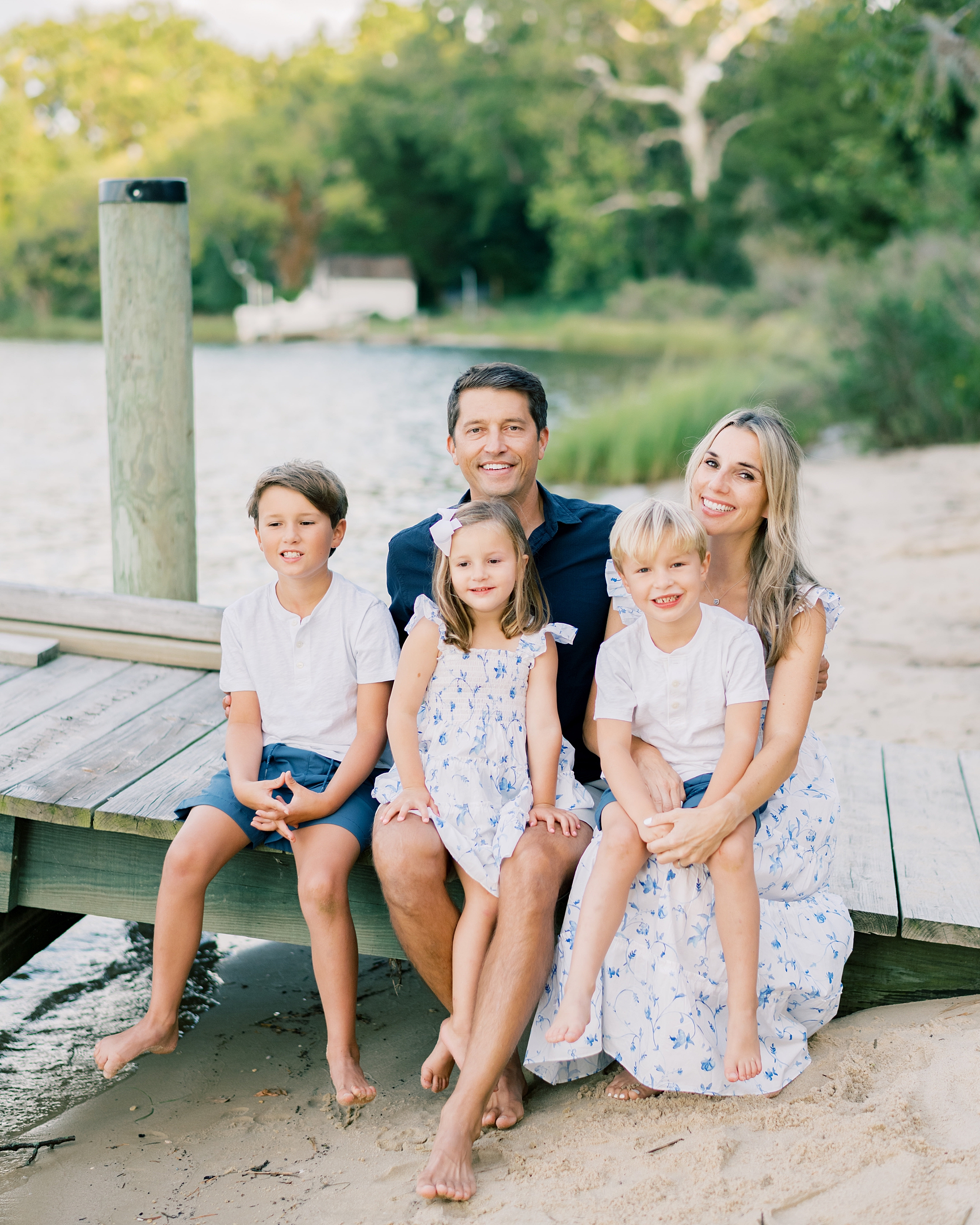 family sits on pier at family home in Southern Maryland