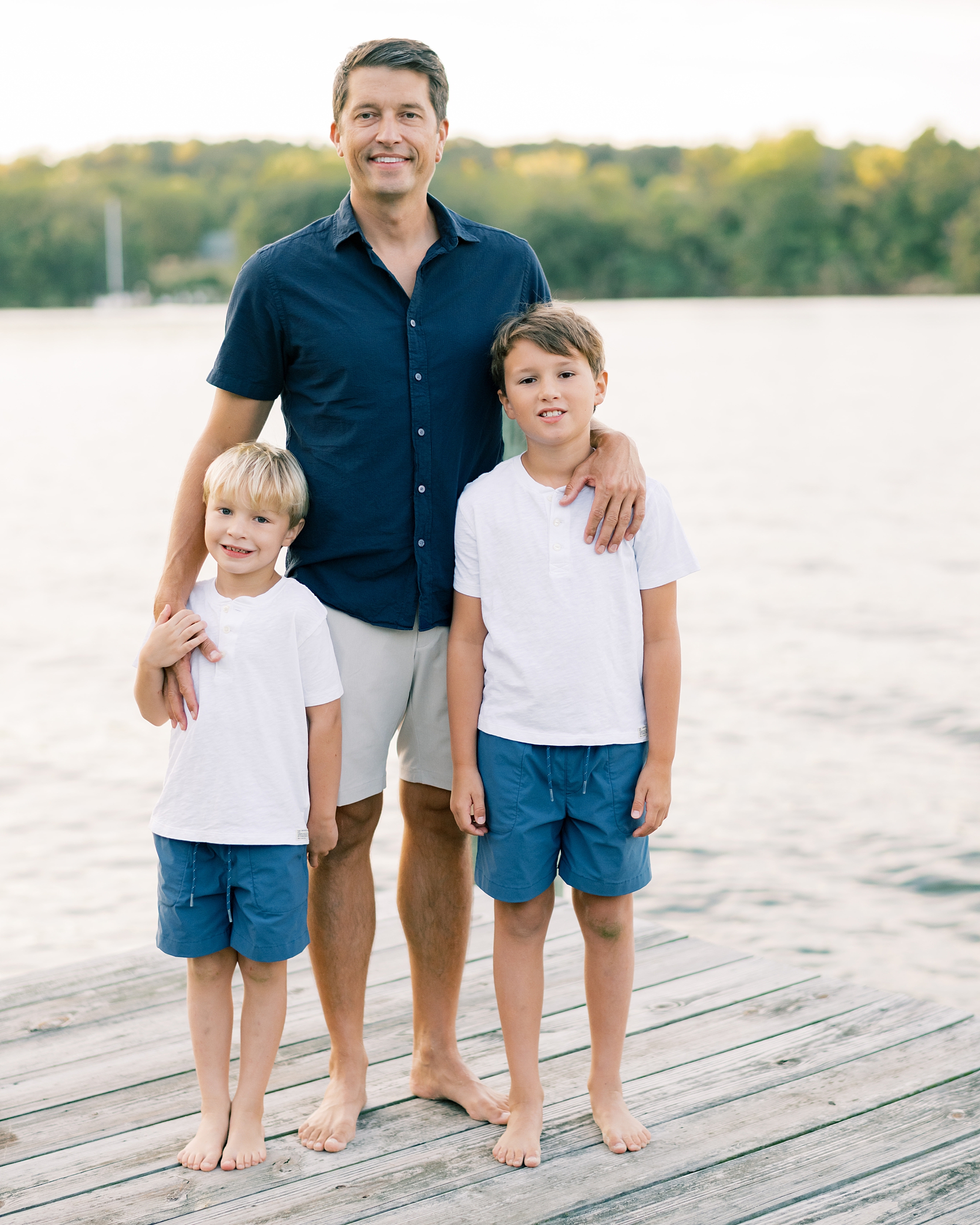 dad with 2 sons on pier by the water 