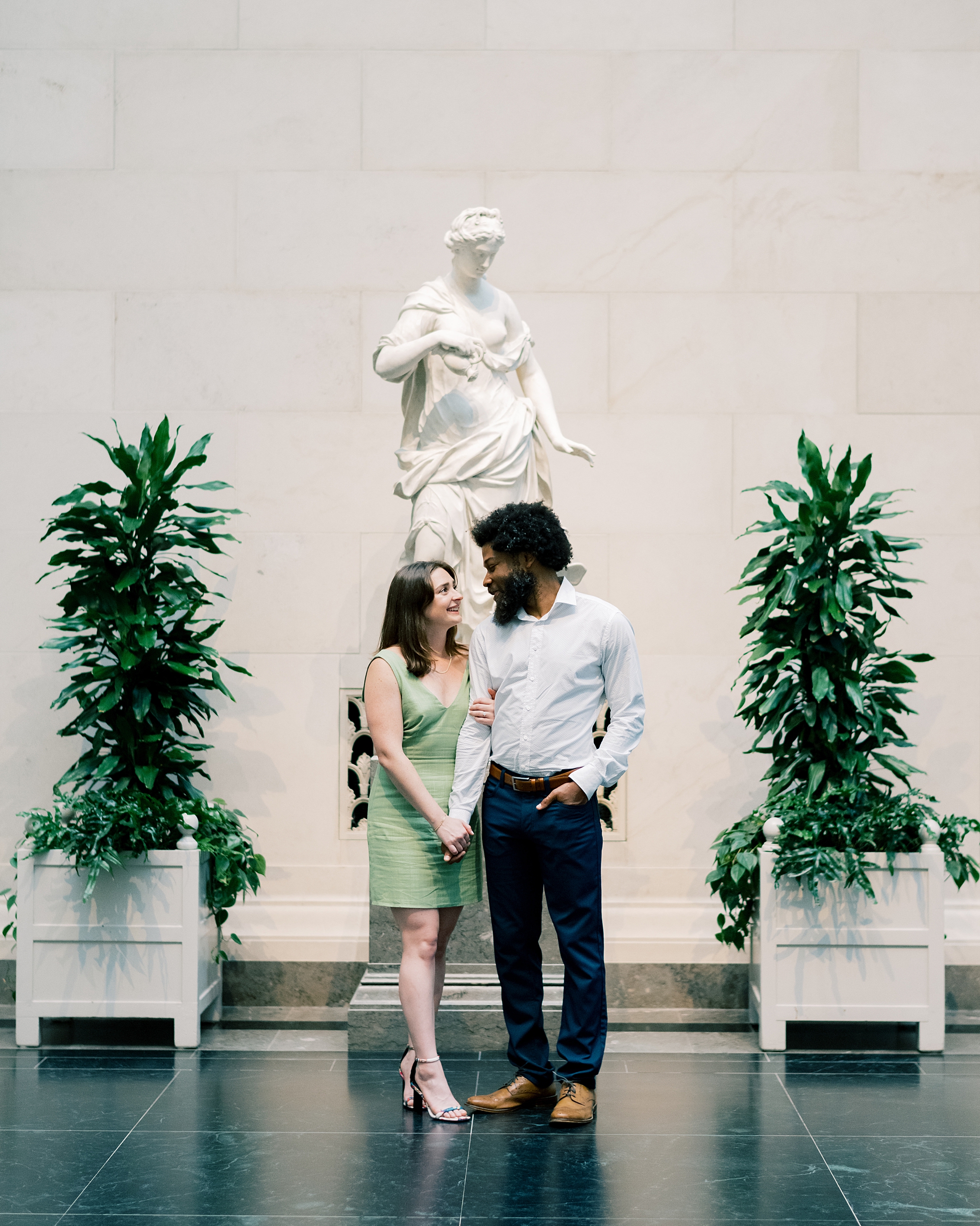 couple stand by white statue 