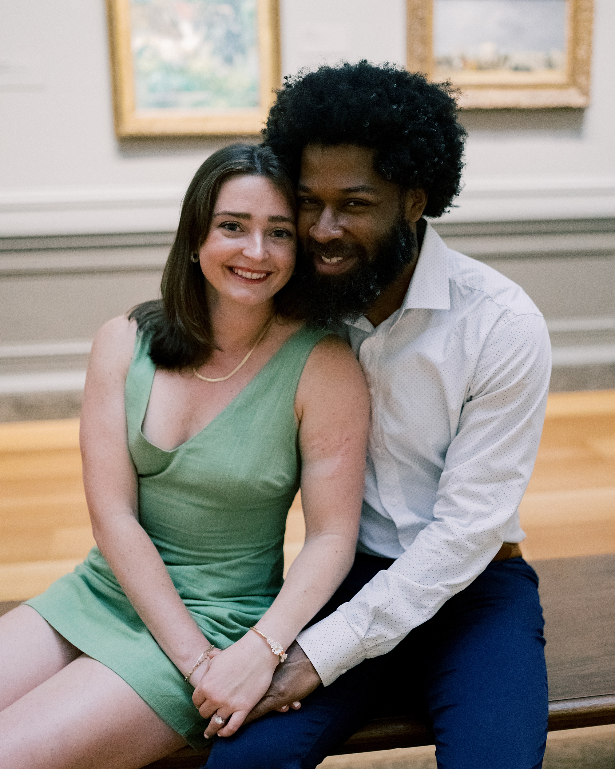 couple sit on bench in art gallery