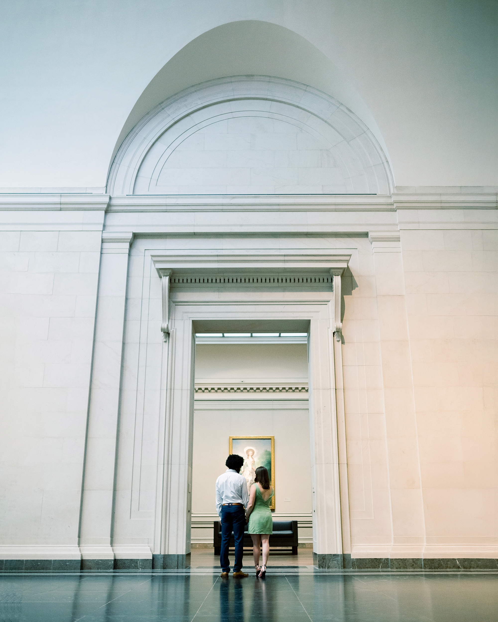 couple walk through doorway inside National Gallery of Art 