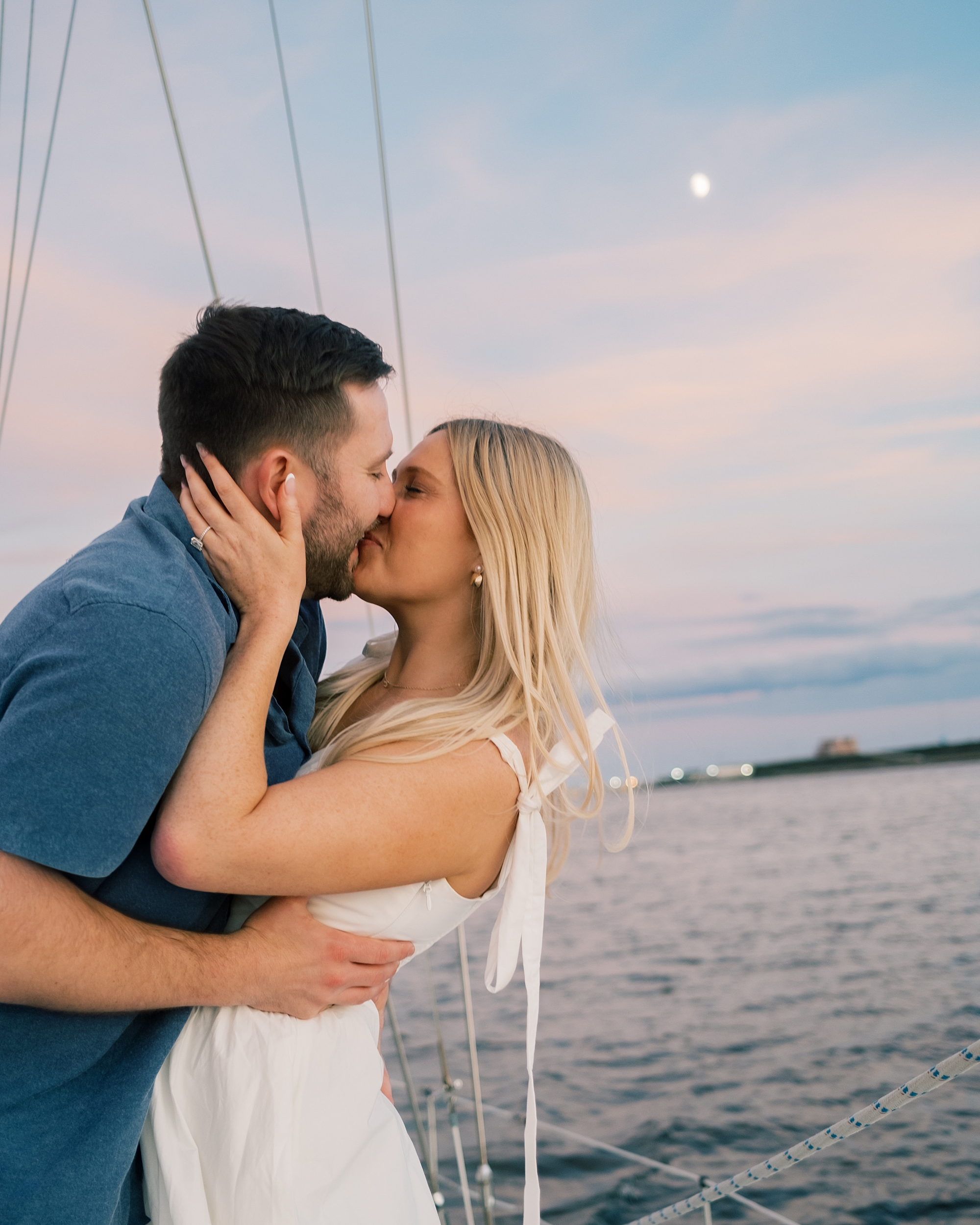 couple kiss during sunset sailboat cruise