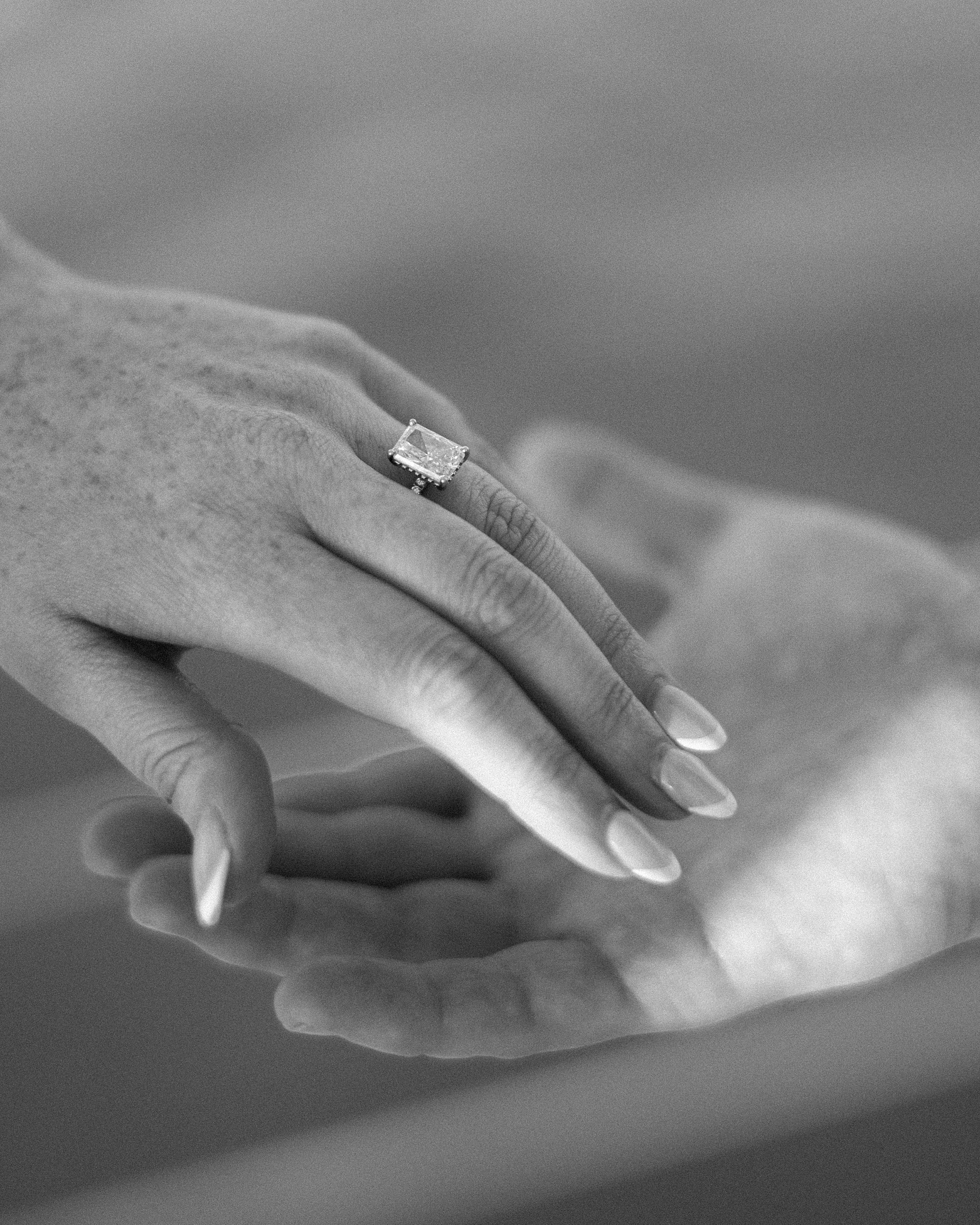 couple hold hands showing off engagement ring 
