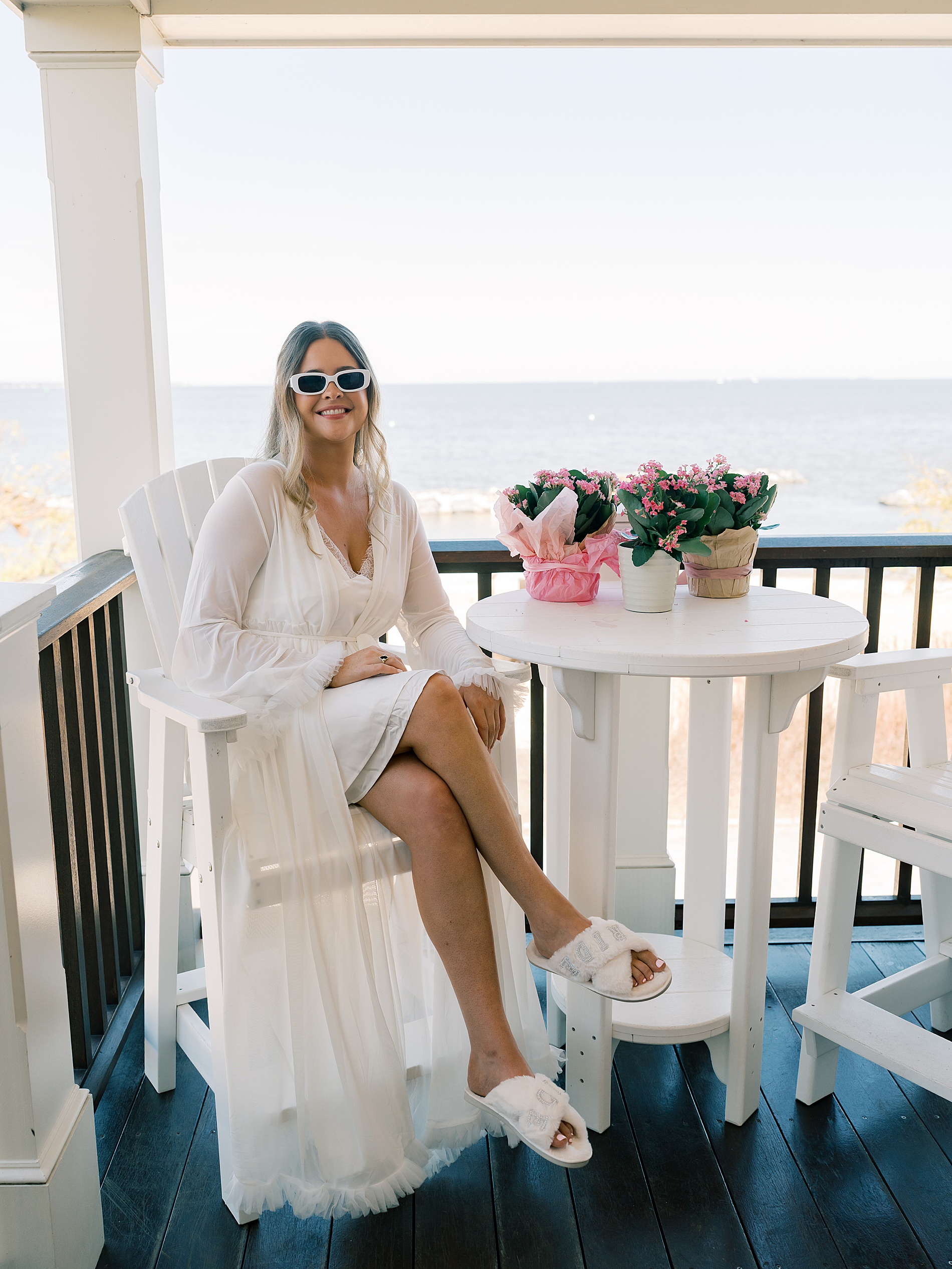 bride sits on balcony overlooking the Bay