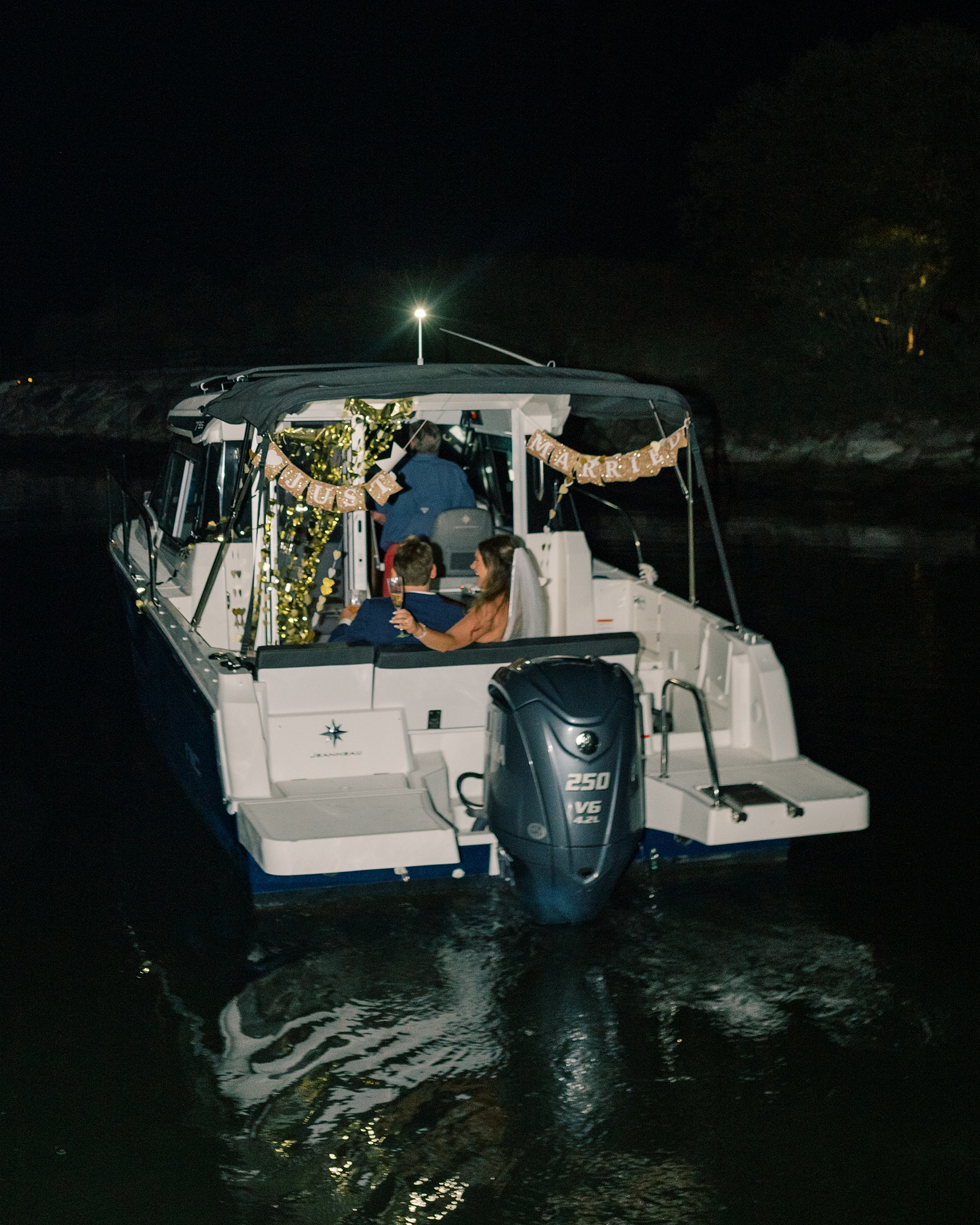 newlyweds drive off in boat at  Herrington on the Bay wedding