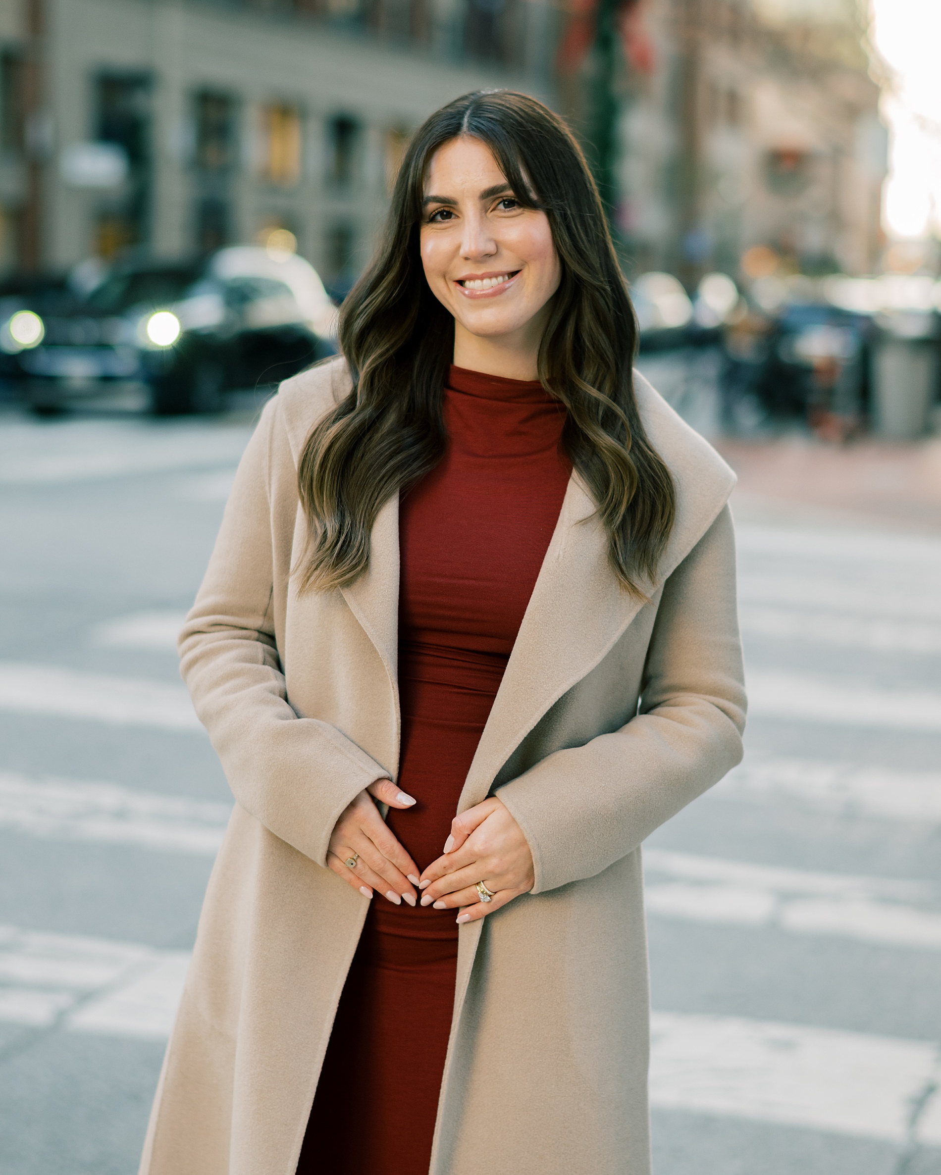 woman in red dress with tan jacket on in Baltimore, MD