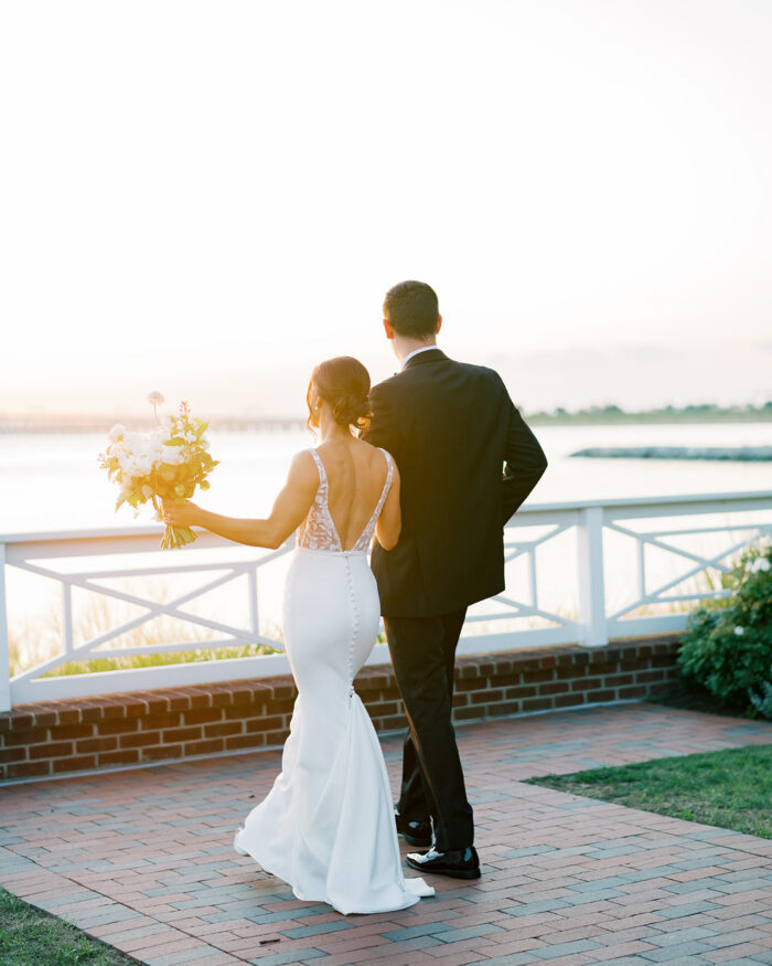 bride and groom face the Chesapeake bay during golden hour wedding portraits 