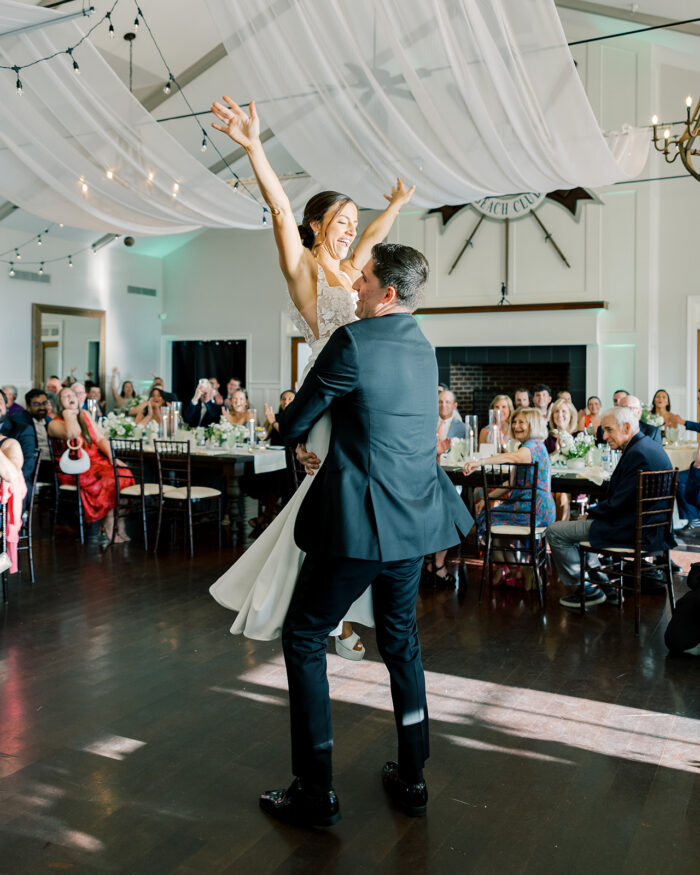 groom lifts bride up in first dance 