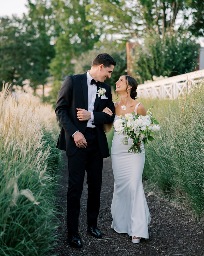 newlyweds surrounded by lush greenery arm in arm 