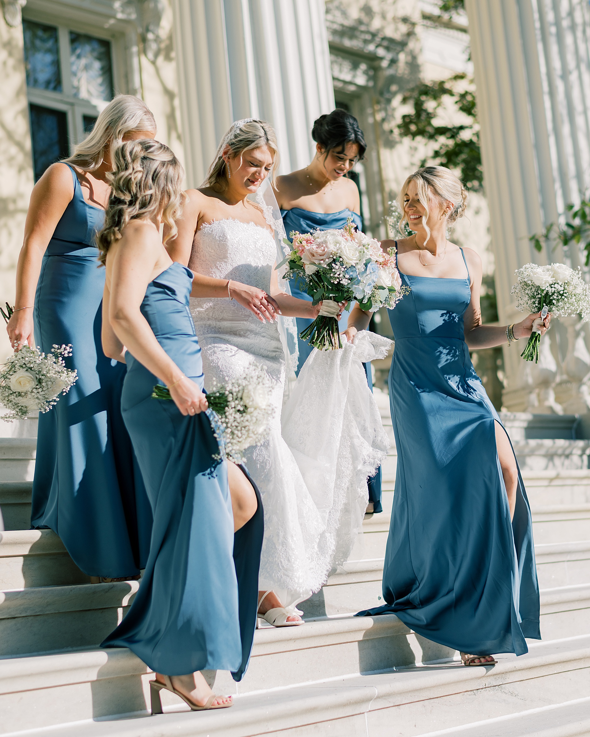 bride walks down stairs with bridesmaids 