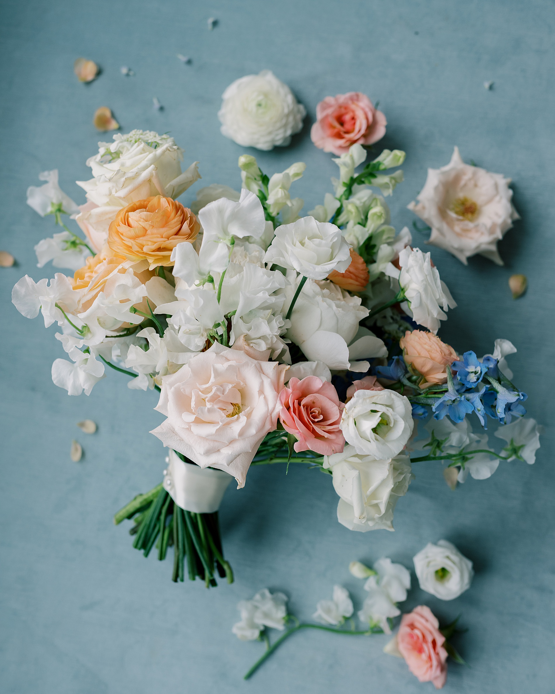 summer bridal bouquet with soft florals and pop of peach, pink, and light blue