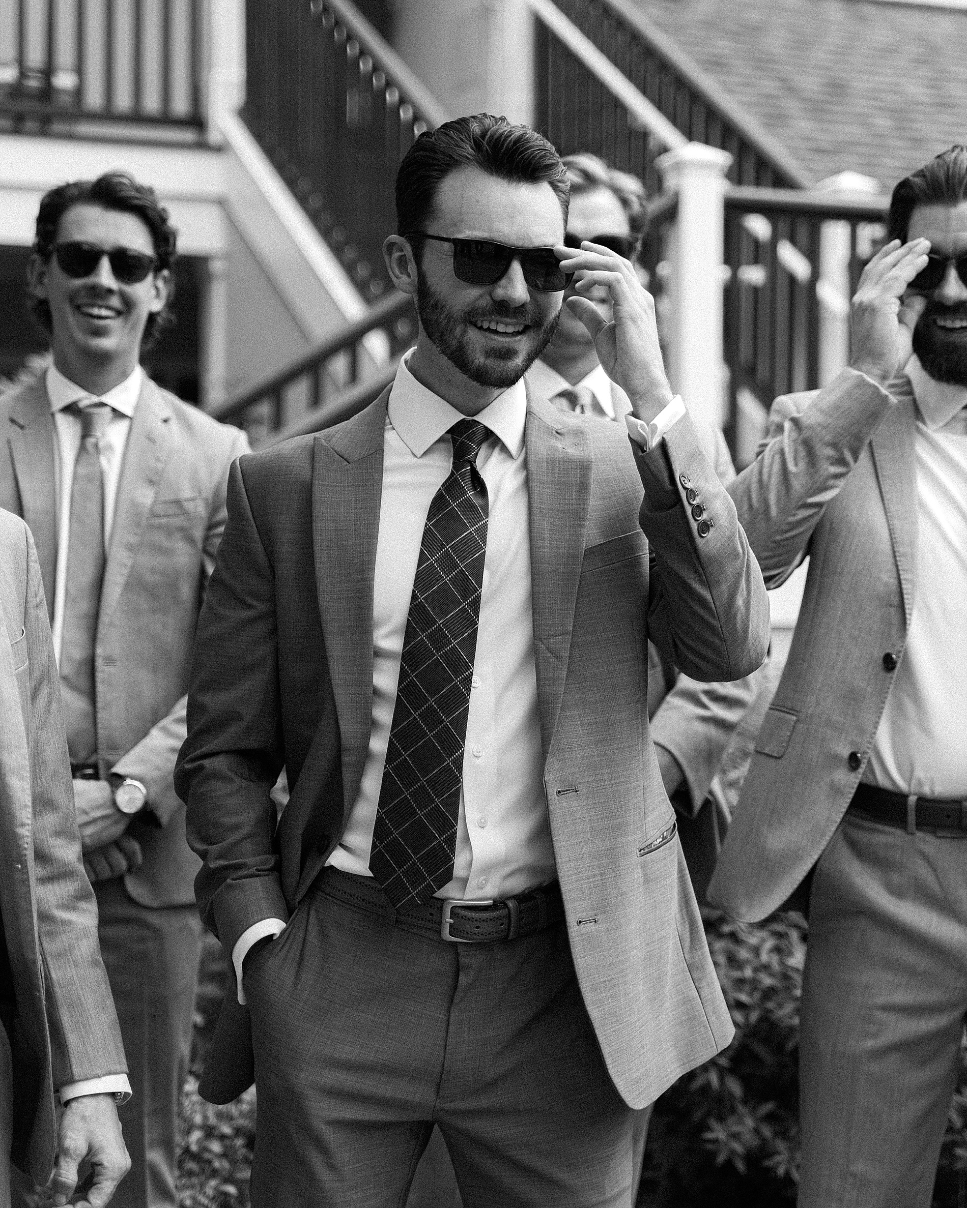 groom and groomsmen walk with sunglasses 