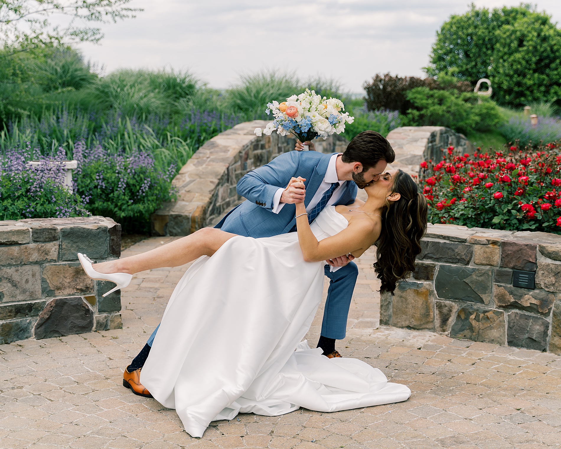 romantic wedding portraits of groom kissing his bride as he dips her down 