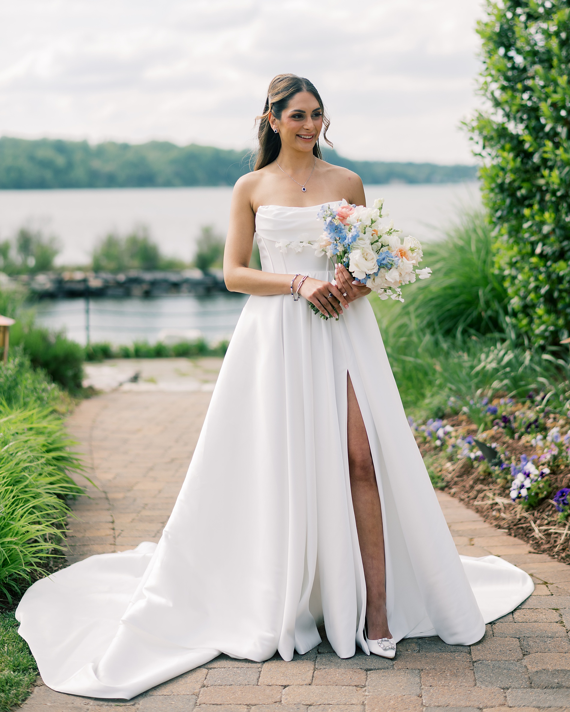bride in strapless wedding dress with high leg slit and summer bridal bouquet 