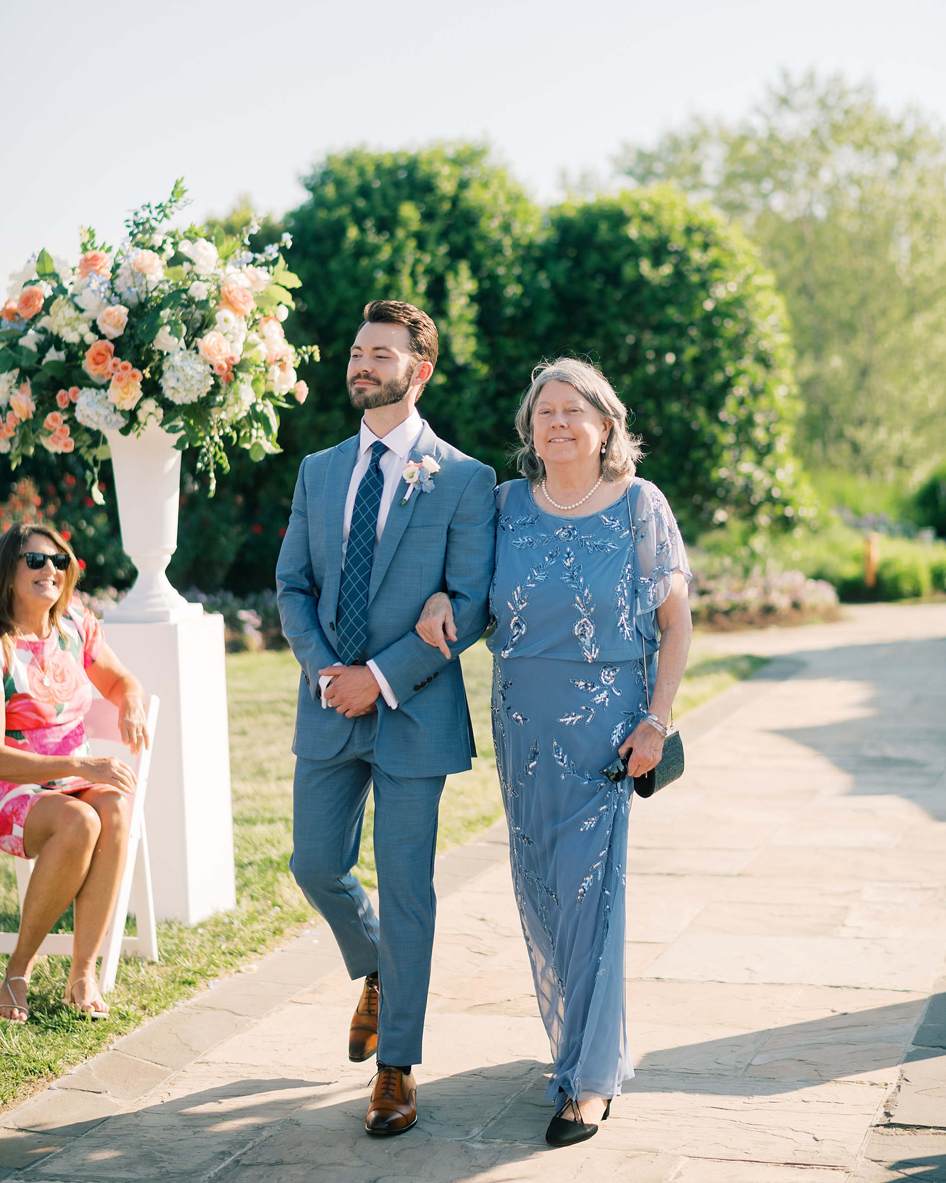 groom walks down the aisle with mom 
