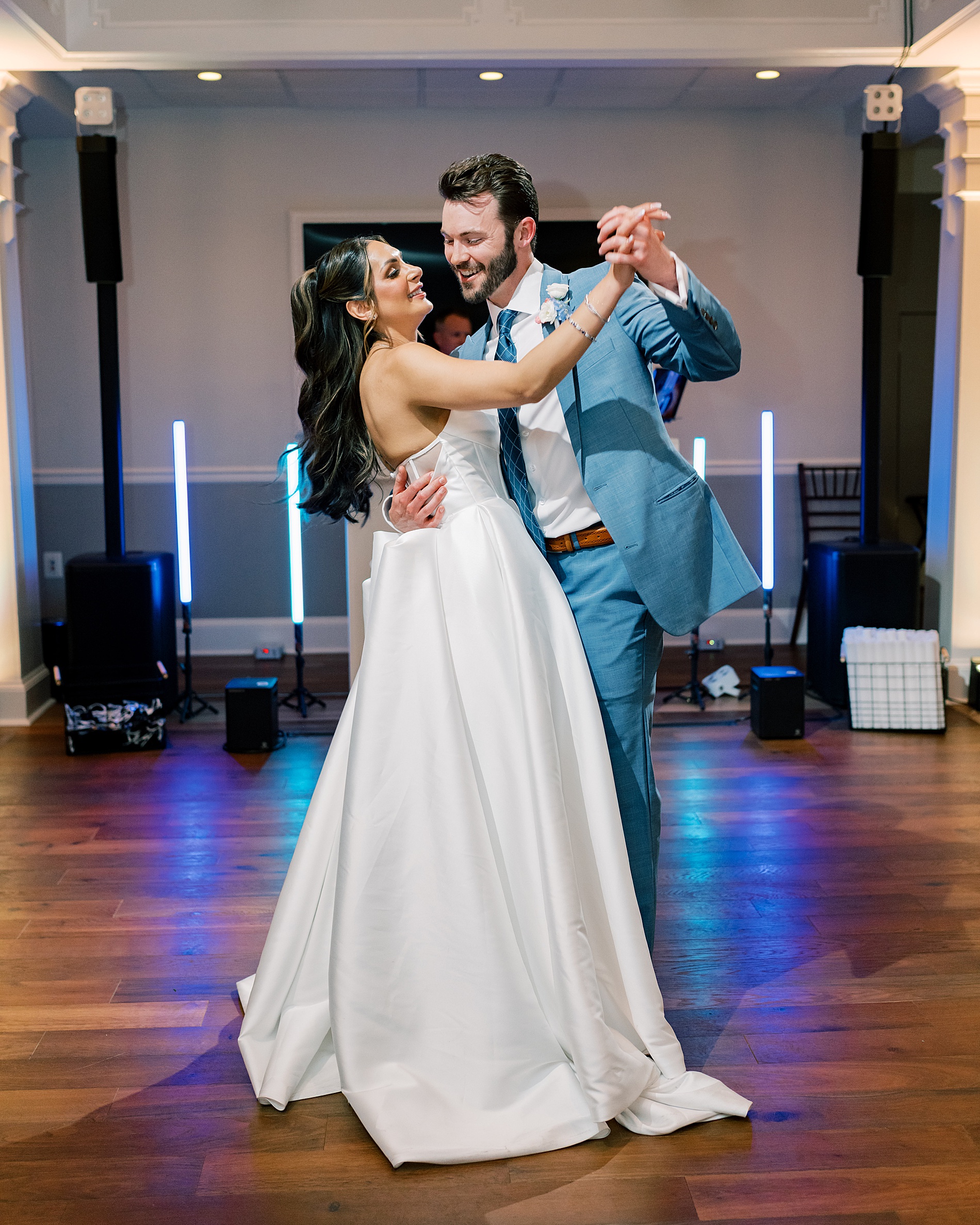 bride and groom smile during their first dance together as husband and wife 