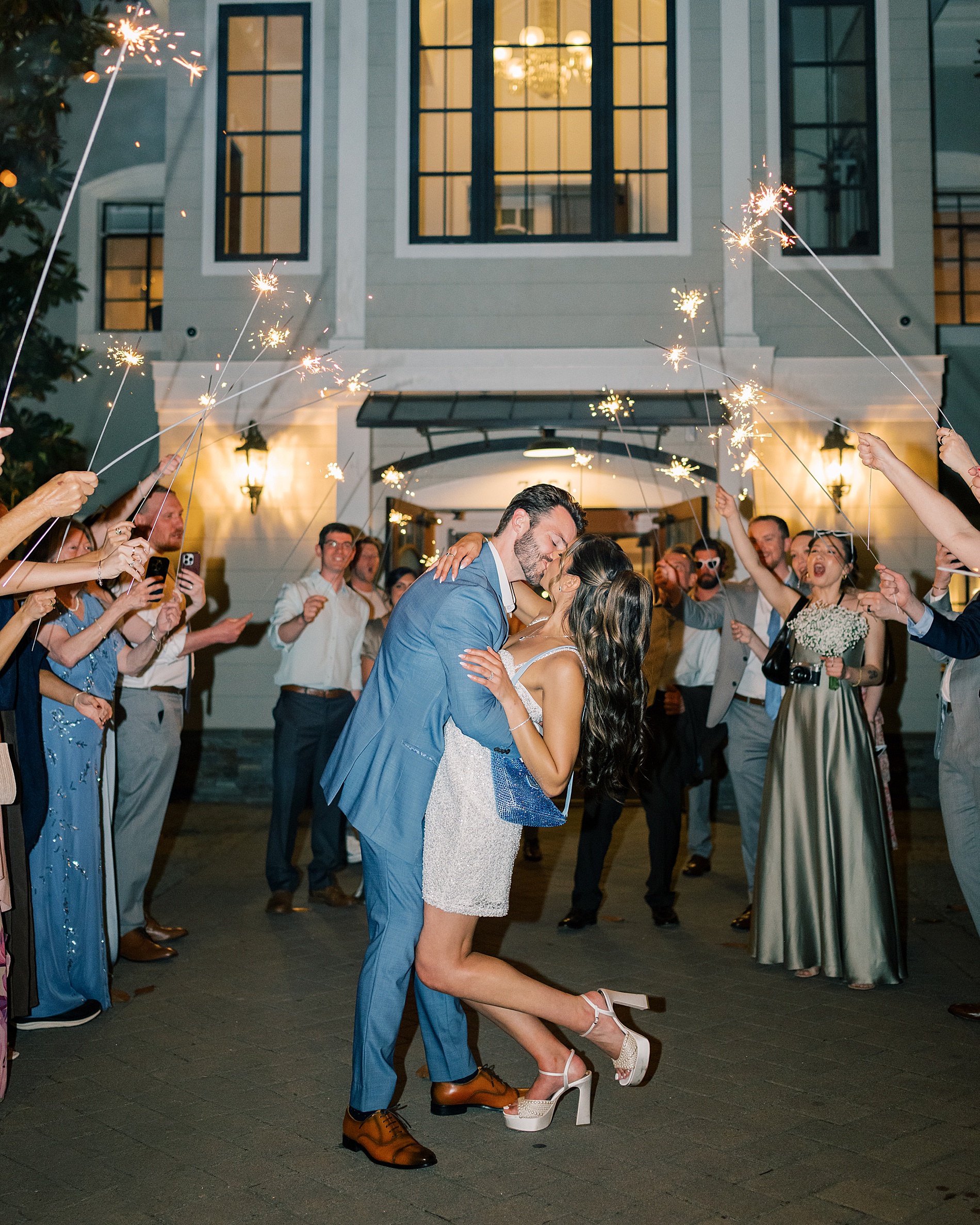 newlyweds kiss as they exit their wedding in a sparkler send off 
