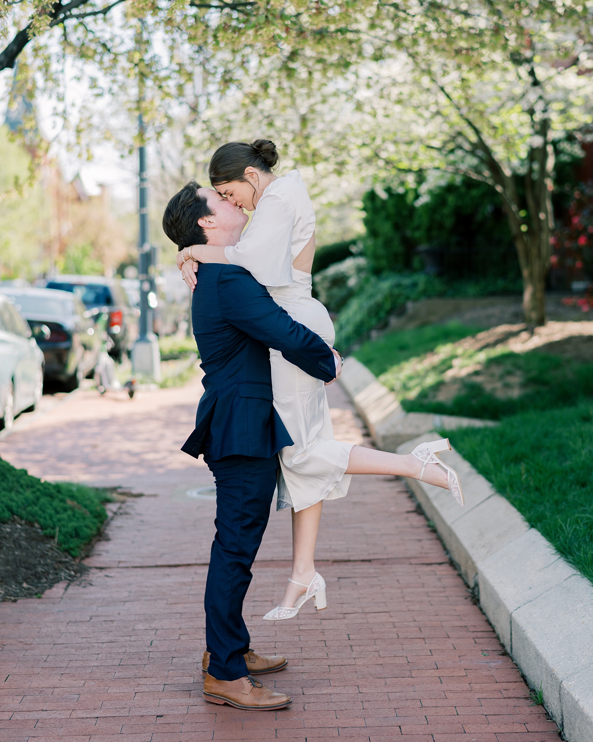 romantic engagement photos in Capitol Hill area as man lifts his fiancé up in his arms as they kiss