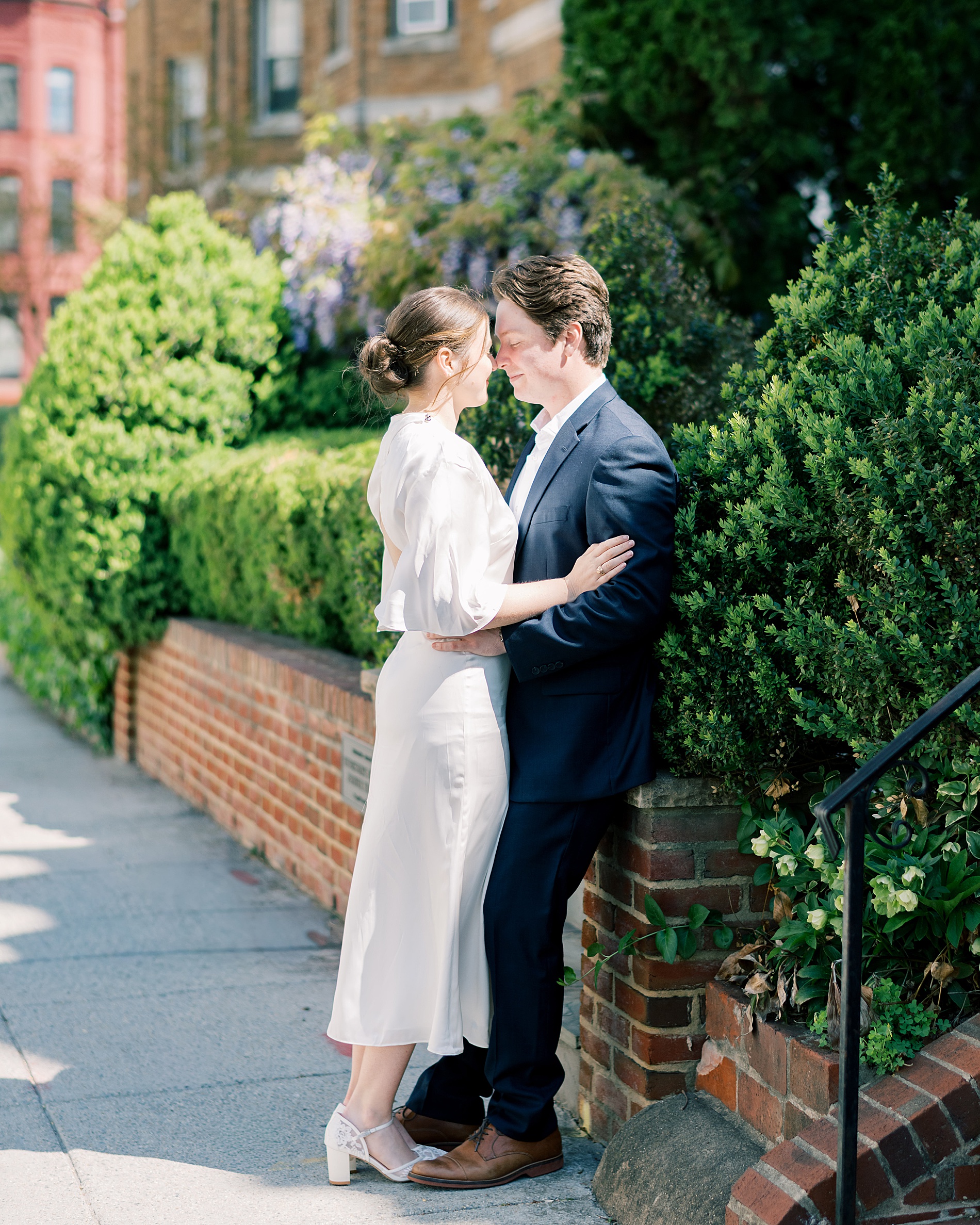 couple lean in together on sidewalk of residential street in DC 