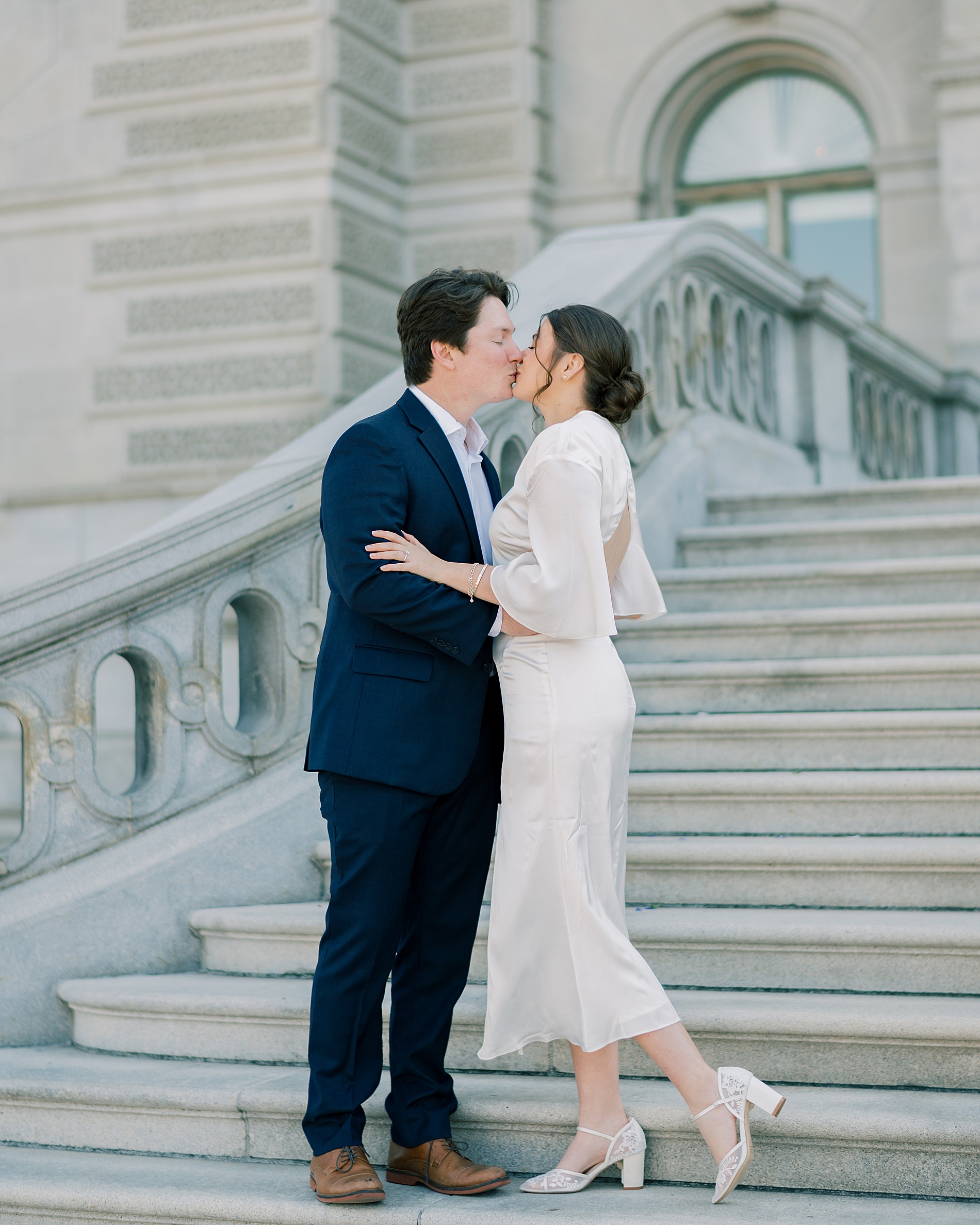 engaged couple kiss on steps of the Library of Congress in DC