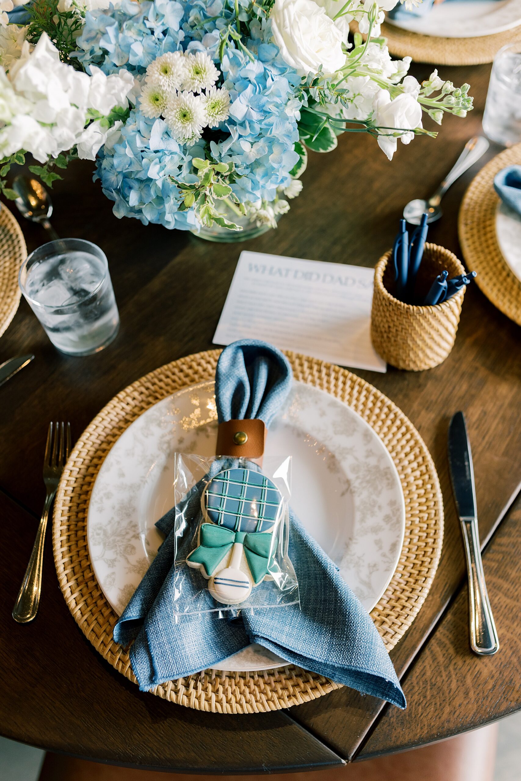 classic place setting at baby boy shower with navy napkins and custom sugar cookies 